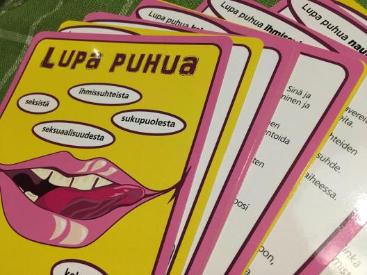 Kuvassa on korttipakka, jonka päällimmäisessä kortissa punaiset, flirttailevat huulet keltaisella pohjalla sekä teksti: Lupa puhua seksistä, ihmissuhteista, seksuaalioikeuksista, sukupuolesta.