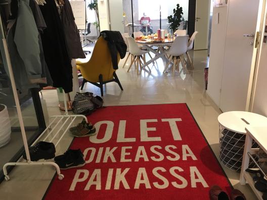 Kuvassa näkyy Propellipäiden työtilan eteinen, jossa on punainen matto, jossa lukee "olet oikeassa paikassa".