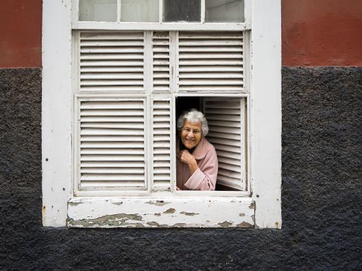 Vanha nainen kerrostalon ikkunassa