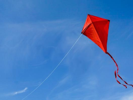Tuuli-hankkeen hankekuva. Punainen leija sinisellä taivaalla.