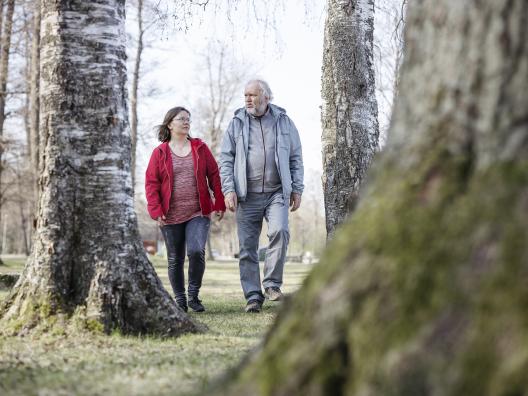 Nainen ja mies kävelyllä metsässä.