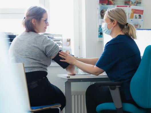 Ammattilainen mittaa verenpainetta asiakkaalta