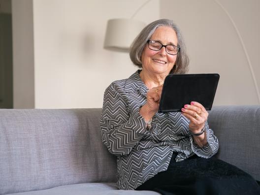 Old woman looking at tablet.