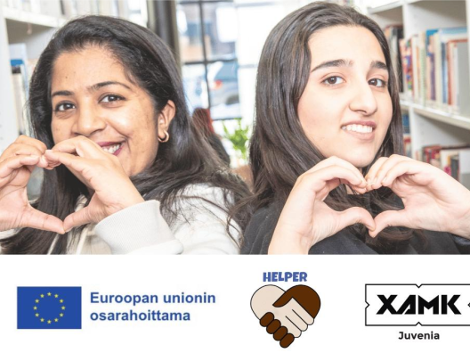 Kaksi maahanmuuttanutta muodostaa käsillään sydämen ja katsoo hymyillen kameraan