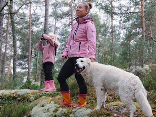 Nainen, lapsi ja koira luonnossa. Kuvituskuva