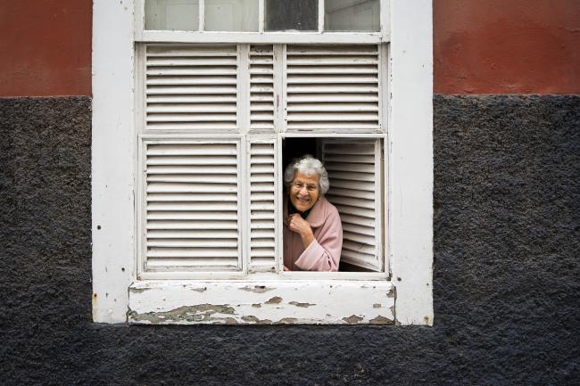 Vanha nainen kerrostalon ikkunassa