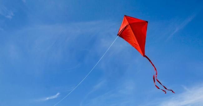 Tuuli-hankkeen hankekuva. Punainen leija sinisellä taivaalla.
