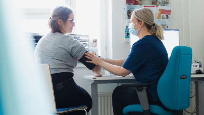 Ammattilainen mittaa verenpainetta asiakkaalta