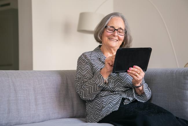 Old woman looking at tablet.