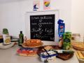 Keittiön työpöytä, jossa liitutaulussa teksti Sinun keittiösi neljällä kielellä: suomi, somali, arabia ja dari