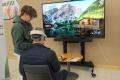 Sedussa tieto- ja viestintätekniikkaa opiskeleva nuori opastaa Digiarki-tapahtumassa kävijää käyttämään VR-laseja.